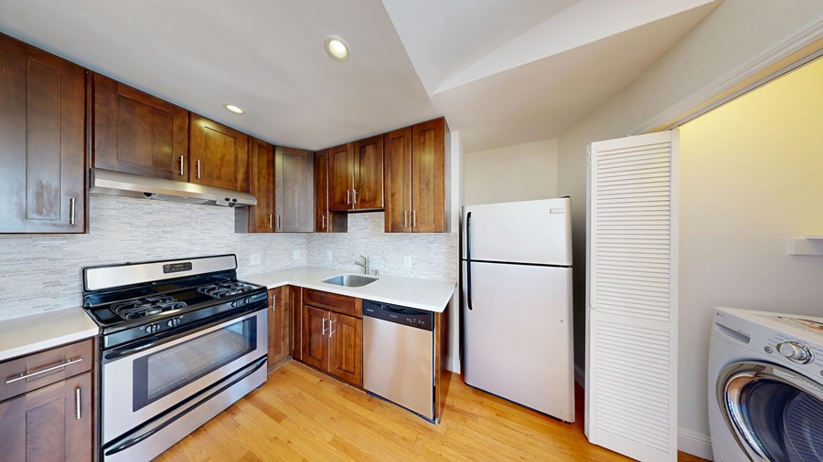 A modern kitchen with wooden cabinets and stainless steel appliances.